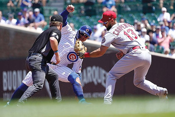 Matt Carpenter of the Cardinals shows second base umpire Mike Muchlinski the ball after catching Joc Pederson of the Cubs trying to steal second during the first inning of Friday afternoon's game in Chicago.