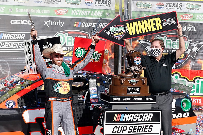 In this July 19, 2020, file photo, Texas Motor Speedway president and general manager Eddie Gossage, right, holds a "Winner" sign as Austin Dillon, left, celebrates by firing six-shooters after winning the NASCAR Cup Series auto race at Texas Motor Speedway in Fort Worth, Texas. NASCAR is providing quite a night to mark the 25th season of racing at Texas Motor Speedway, and sendoff for track president and showman Eddie Gossage, whose last race is Sunday after overseeing the track from its groundbreaking in 1995, two years before it opened. (AP Photo/Ray Carlin, File)