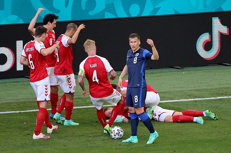 Denmark's players go to his teammate Christian Eriksen after he collapsed during the Euro 2020 soccer championship group B match between Denmark and Finland at Parken stadium in Copenhagen, Denmark, Saturday, June 12, 2021. (Wolfgang Rattay/Pool via AP)