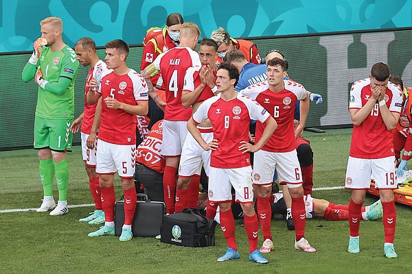 Denmark players react as their teammate Christian Eriksen is on the ground Saturday during the Euro 2020 soccer championship group B match against Finland in Copenhagen, Denmark.