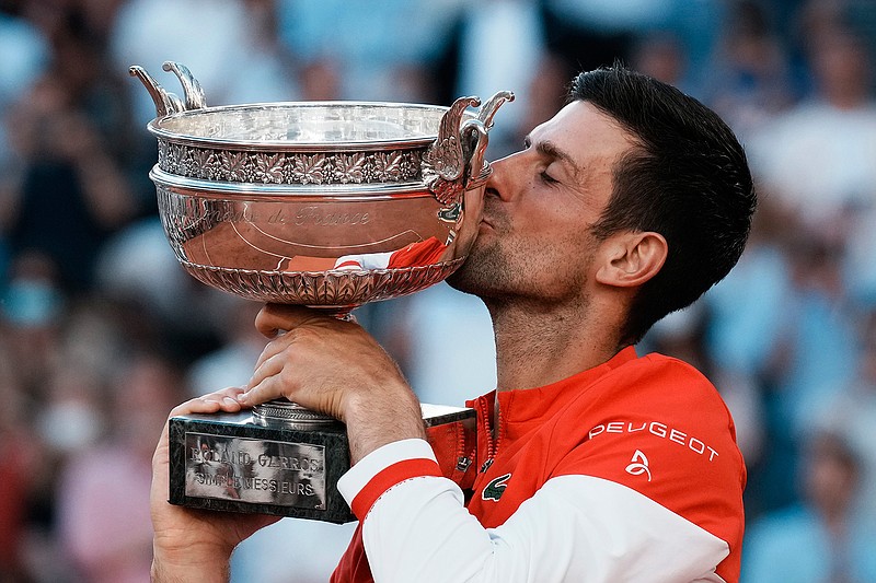 Serbia's Novak Djokovic kisses the cup after defeating Stefanos Tsitsipas of Greece during their final match of the French Open tennis tournament at the Roland Garros stadium Sunday, June 13, 2021 in Paris. Djokovic won 6-7 (6), 2-6, 6-3, 6-2, 6-4. (AP Photo/Michel Euler)