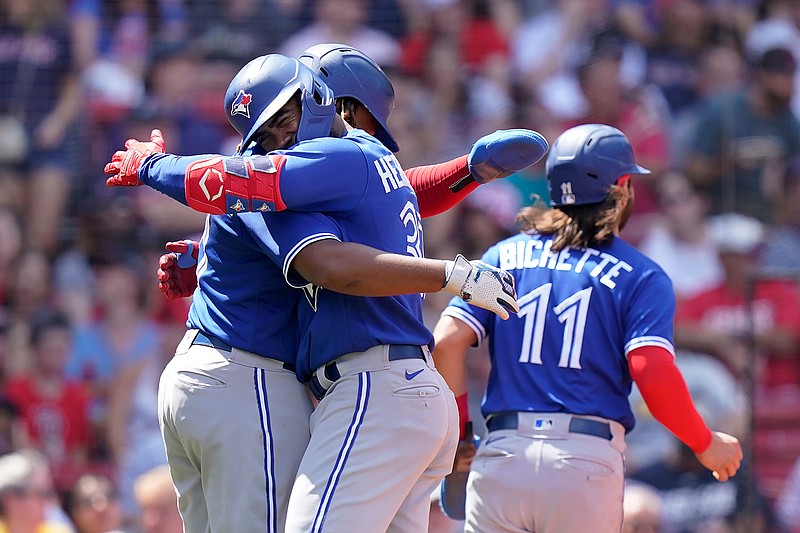 Toronto Blue Jays right fielder Teoscar Hernandez, front left, celebrates with Vladimir Guerrero Jr., behind left, and Bo Bichette (11) after Hernandez hit a three-run home run in the fourth inning of a baseball game against the Boston Red Sox, Sunday, June 13, 2021, in Boston. The Blue Jays won 18-4. (AP Photo/Steven Senne)