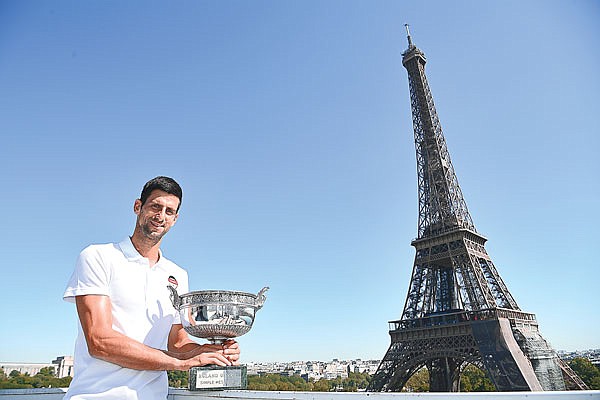 Novak Djokovic poses with French Open men's singles trophy in front of the Eiffel Tower Monday in Paris.