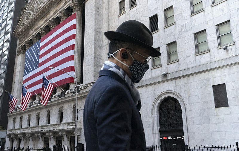 FILE - In this Nov. 16, 2020 file photo a man wearing a mask passes the New York Stock Exchange in New York. Stocks are edging mostly lower in early trading on Wall Street Tuesday, June 15, 2021, a day after the S&P 500 and the Nasdaq hit their latest record highs. Technology stocks, which had led the gains a day earlier, were in the losing column.  (AP Photo/Mark Lennihan, File)