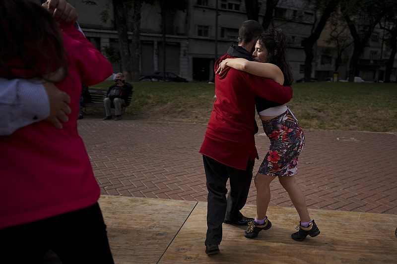 FILE - In this June 6, 2021 file photo, a couple dances tango at a park amid the COVID-19 pandemic lockdown in Buenos Aires, Argentina. Nostalgia for dance makes many tango dancers, or tangueros, defy restrictions with clandestine milongas in closed places or public spaces. (AP Photo/Natacha Pisarenko, File)