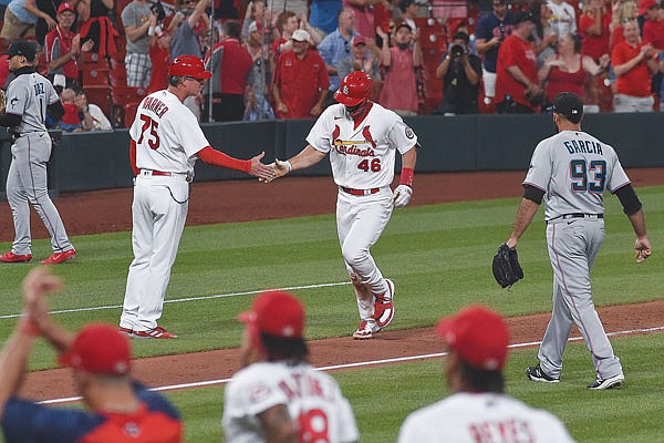 Paul Goldschmidt of the Cardinals is congratulated by third base coach Ron "Pop" Warner after hitting a game-ending home run in the bottom of the ninth inning of Tuesday night's game against the Marlins at Busch Stadium.