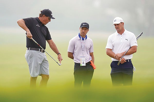 Phil Mickelson talks with golf coach Chris Como and Bryson DeChambeau on the 12th hole during a practice round Monday at Torrey Pines in San Diego.