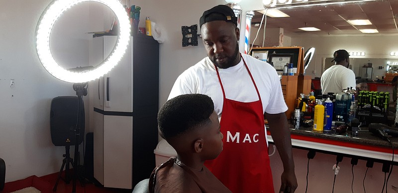Maxwell Hamilton works with a young customer at The Fade Room on New Boston Road in Texarkana. He says his business is for everyone who wants barber and beauty services in a comfortable environment.