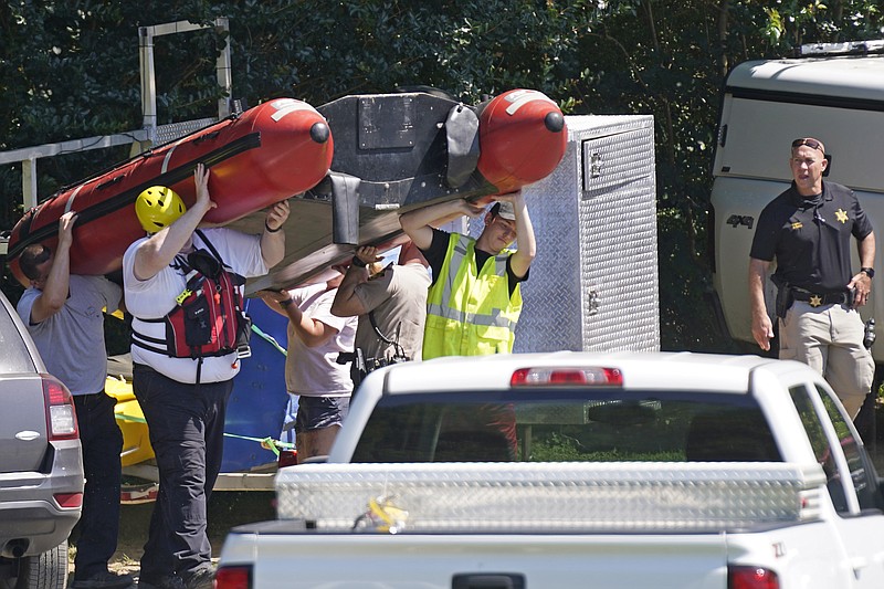 Rescue personnel stage along the Dan River in Eden, N.C., Friday, June 18, 2021. The search for two missing tubers continues after three others were found dead and four more were pulled from the water after the group went over an 8-foot dam Wednesday. (AP Photo/Gerry Broome)