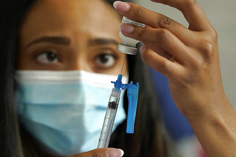 Licensed practical nurse Yokasta Castro, of Warwick, R.I., draws a Moderna COVID-19 vaccine into a syringe at a mass vaccination clinic, Wednesday, May 19, 2021, at Gillette Stadium, in Foxborough, Mass. A month after every adult in the U.S. became eligible for the vaccine, a distinct geographic pattern has emerged: The highest vaccination rates are concentrated in the Northeast, while the lowest ones are mostly in the South.