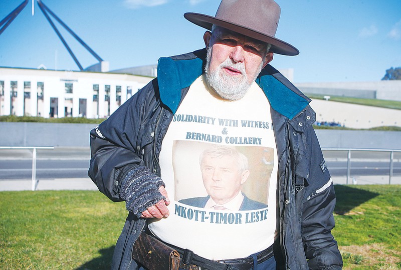 Demonstrator Dierk von Behrens protests Thursday outside Parliament House in Canberra, Australia, against the prosecution of lawyer Bernard Collaery whose picture is on the demonstrator's shirt. Critics of the secret prosecutions of a former Australian spy and his lawyer argue they are another example of a government concealing political embarrassment under the guise of national security.
