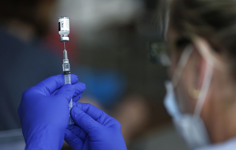 Nurse Jody Berry draws a syringe full of the Johnson & Johnson COVID-19 vaccine at a clinic at Mother's Brewing Company in Springfield, Mo., on Tuesday, June 22, 2021. As the U.S. emerges from the COVID-19 crisis, Missouri is becoming a cautionary tale for the rest of the country: It is seeing an alarming rise in cases because of a combination of the fast-spreading delta variant and stubborn resistance among many people to getting vaccinated. (Nathan Papes/The Springfield News-Leader via AP)