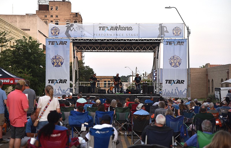 A crowd gathers as local band The Moss Brothers performs Thursday evening on Main Street in front of the Perot Theatre in downtown Texarkana. Drinks were served by Pecan Point and Redbone Magic Brewing, allowing attendees of the Texas-side event to take advantage of the newly expanded entertainment district. TEXAR Federal Credit Union held the free event and plans to hold the same sort of evening on the Arkansas side of town next month.