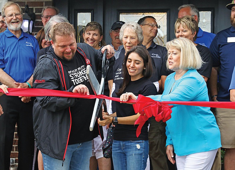 Rob Warner, left, and Oly Warner, center, cut the ribbon Tuesday as First Lady Teresa Parson, right, assists during a ceremony celebrating the opening of the Warner's Coyote Hill foster home.