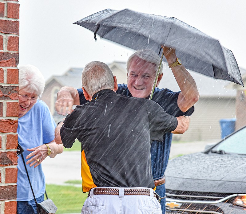 Julie Smith/News TribuneBrent Hardy, back to camera, was so excited to meet his brother, Bill, that the pouring rain didn't stop him from running out to greet him and his wife, Juanita. Brothers Bill and Brent Hardy met Wednesday, June 30, 2021, for the first time. Brent, who lives in Jefferson City and Bill, who lives in Texas, only found out a little over a year ago about the existence of each other. Bill and his wife, Juanita, had planned to make the trip to Jefferson City last year but didn't due to health concerns around Covid-19. Wednesday saw the brothers meet for the first time. The Texas couple brought some very personal gifts to give to their newly-found brother and brother-in-law, including the U.S. Flag that was on their father's casket.