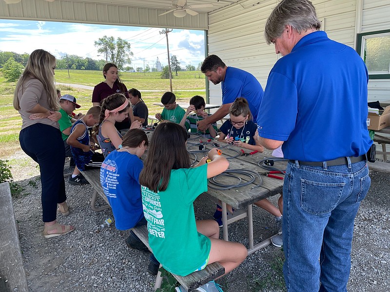 <p>Democrat photo/Kaden Quinn</p><p>Participants at last month’s 4-H camp work with Co-Mo Electric employees to put together extension cords at the Moniteau County Fairgrounds.</p>