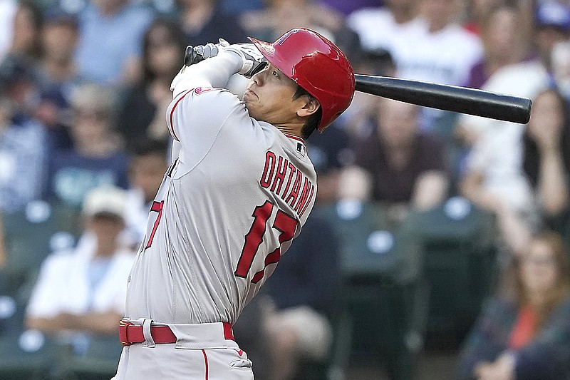 Shohei Ohtani of the Angels watches his solo home run during the third inning of Friday's game against the Mariners in Seattle.