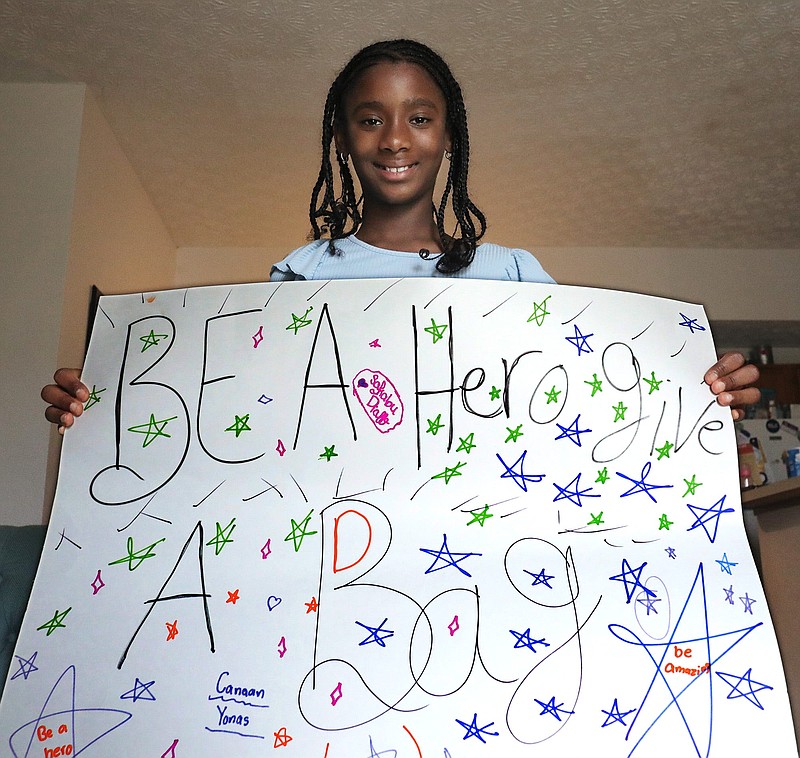 Pickerington middle school student Safiatou Diallo, 10, founded an organization called Greater Purpose Africa to collect school supplies for children in Guinea, West Africa. She holds a sign she made to spread the word about her project. (Fred Squillante/The Columbus Dispatch/TNS)