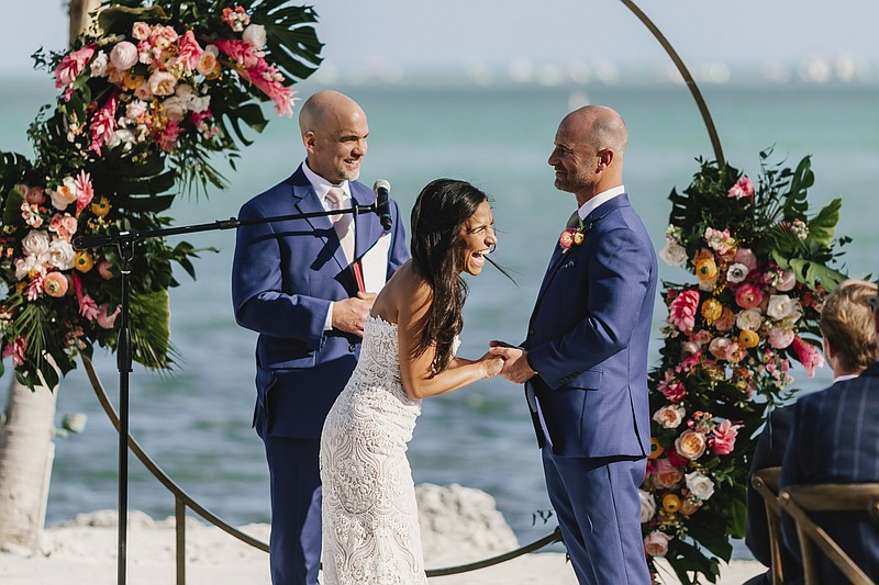 Associated Press sportswriter Larry Lage, left, officiates the wedding of Ryan Rutledge and Natalie LaRocca at the Postcard Inn Beach Resort and Marina in Islamorada, Fla. on March 27, 2021. (Photo courtesy of Lukas Guillaume via AP)