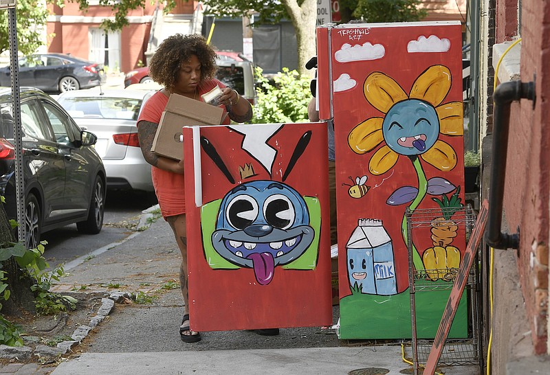 Jammella Anderson, who started Free Food Fridge Albany, restocks one of her six sidewalk refrigerators with produce, Friday, June 25, 2021, in Albany, N.Y.  The program helps feed South End residents who would face long walks or a bus trip to buy food at a supermarket. (AP Photo/Hans Pennink)