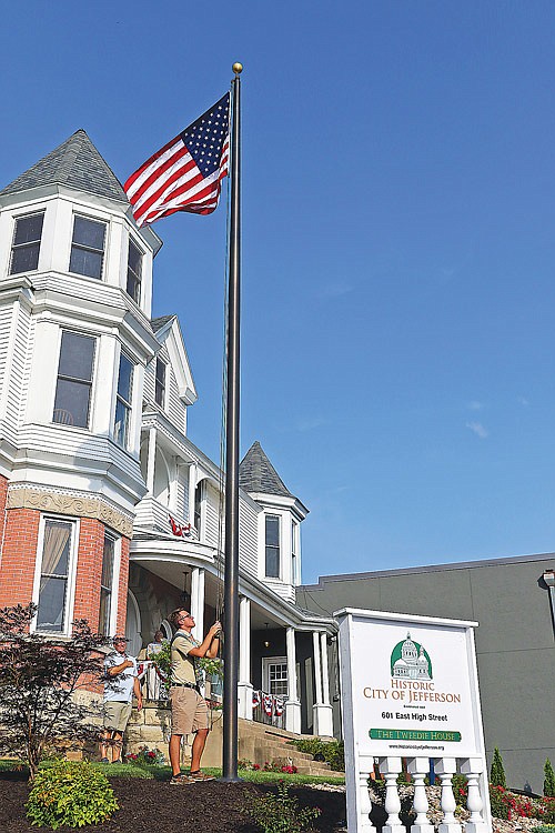 Nathanael Landwehr raises the American flag Wednesday, July 14, 2021, at the Historic City of Jefferson office. It's the first time the flag has been raised on the Tweedie House property since the May 2019 tornado. Landwehr helped plan and raise money for landscaping on the property as an Eagle Scout project. 