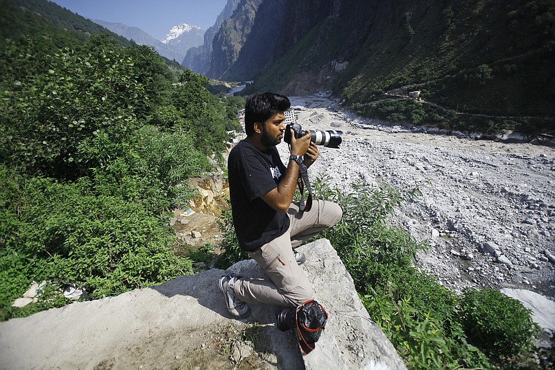 Reuters photographer Danish Siddiqui covers the monsoon floods and landslides in the upper reaches of Govindghat, India, Saturday, June 22, 2013. Afghan government forces battled Friday to retake a border crossing with Pakistan from Taliban insurgents, and the Reuters news agency said one of its photographers was killed in the area. Reuters said Pulitzer Prize-winning photographer Siddiqui, who was embedded with the Afghan special forces, was killed Friday, July 16, 2021, as the commando unit sought to recapture Spin Boldak. (AP Photo/Rafiq Maqbool)