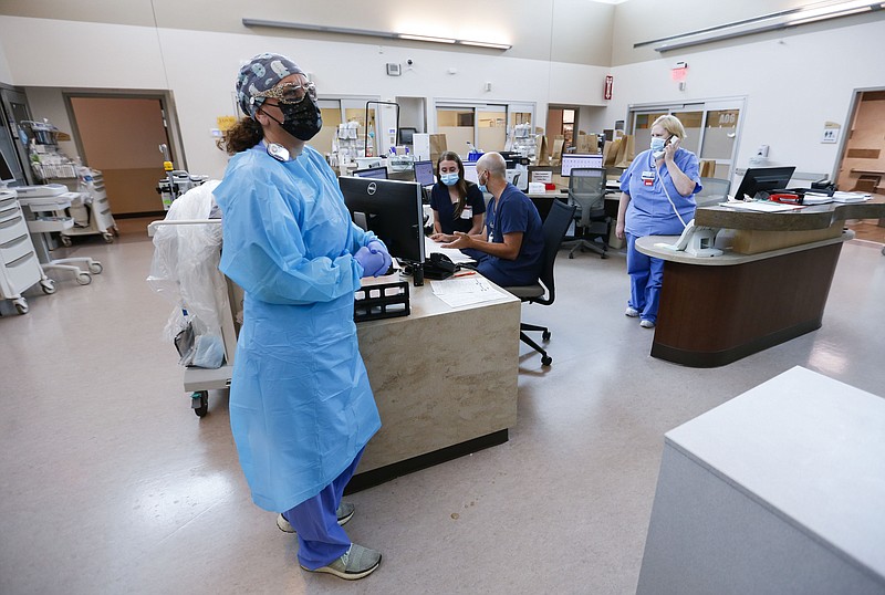 Nurses and doctors in the CoxHealth Emergency Department in Springfield, Mo., wear personal protective equipment to treat patients with COVID-19, Friday, July 16, 2021. Southwest Missouri is seeing a surge in Delta variant cases, with hospitals nearing capacity and requesting help from the state for staffing and an alternative care site. (Nathan Papes/The Springfield News-Leader via AP)
