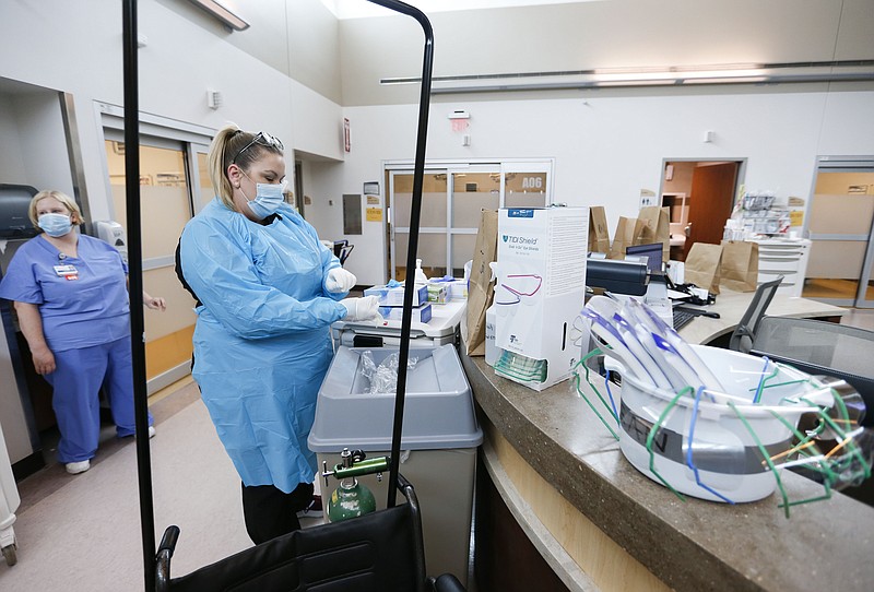 Nurses and doctors in the CoxHealth Emergency Department in Springfield, Mo., don personal protective equipment to treat patients with COVID-19, Friday, July 16, 2021. (Nathan Papes/The Springfield News-Leader via AP)