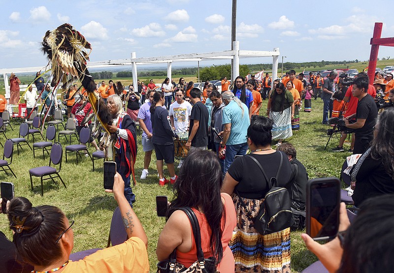 Tribal elder Duane Hollow Horn Bear leads a procession in honor of the nine Rosebud children whose remains are being transported home Friday, July 16, 2021 at the Fort Randall Casino on the Yankton Sioux Reservation in South Dakota. The disinterred remains of nine Native American children who died more than a century ago while attending a government-run school in Pennsylvania are headed home to Rosebud Sioux tribal lands in South Dakota. (Erin Bormett/The Argus Leader via AP)