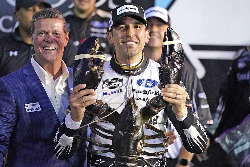 Aric Almirola smiles Sunday as he holds up a giant lobster after winning the NASCAR Cup Series race in Loudon, N.H.