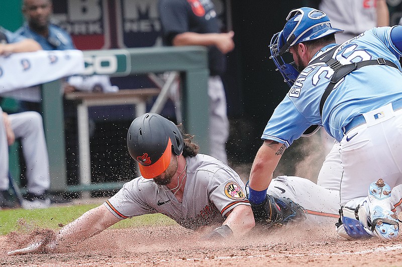 Ryan McKenna of the Orioles beats the tag attempt by Royals catcher Cam Gallagher during the sixth inning of Sunday afternoon's game at Kauffman Stadium.