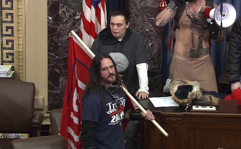 FILE - In this file image from U.S. Capitol Police video, Paul Allard Hodgkins, 38, of Tampa, Fla., front, stands in the well on the floor of the U.S. Senate on Jan. 6, 2021, at the Capitol in Washington. (U.S. Capitol Police via AP, File)