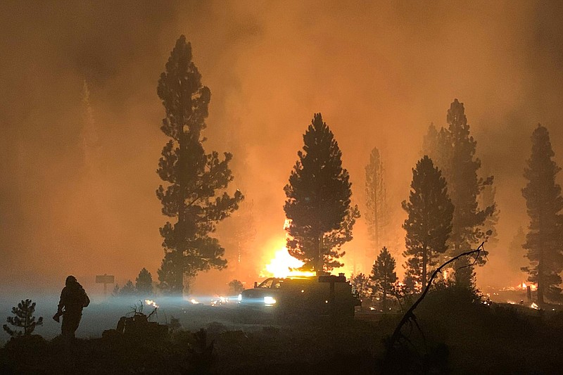 In this photo provided by the Bootleg Fire Incident Command, the Bootleg Fire burns at night in southern Oregon on Saturday, July 17, 2021. The destructive Bootleg Fire, one of the largest in modern Oregon history, has already burned more than 476 square miles (1,210 square kilometers), an area about the size of Los Angeles. The Bootleg Fire is among dozens burning in the parched West.  (Bootleg Fire Incident Command via AP)