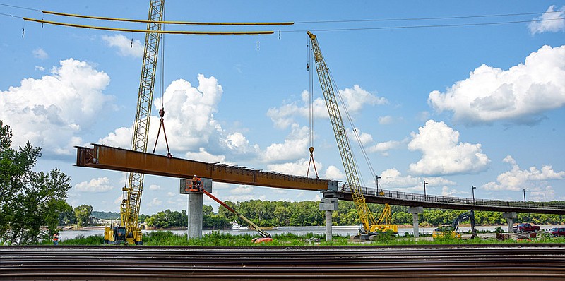 Operators, steel workers and laborers from Phillips Hardy worked in unison Monday, July 19, 2021, to set the next section of steel bridge trusses for the Bicentennial Bridge to Adrian's Island along the Missouri River in Jefferson City. This length is the second to last to be set, with the next piece being 190 feet in length to span the multiple sets of railroad tracks.