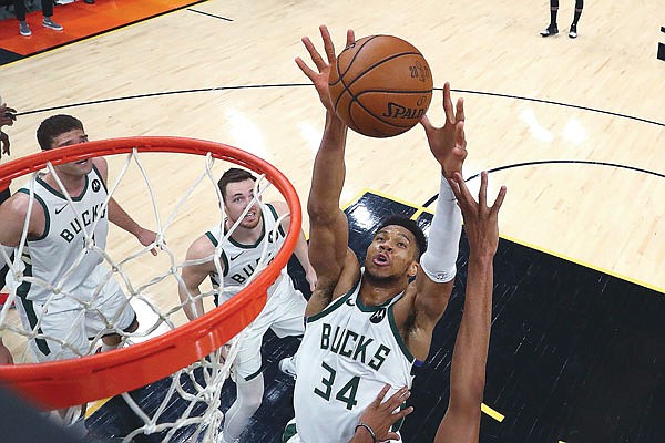 Giannis Antetokounmpo of the Bucks reaches for the ball during Saturday night's Game 5 of the NBA Finals against the Suns in Phoenix.