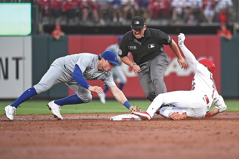 Cubs second baseman Nico Hoerner attempts to tag out the Cardinals' Dylan Carlson, who doubled during the third inning of Tuesday night's game at Busch Stadium in St. Louis.