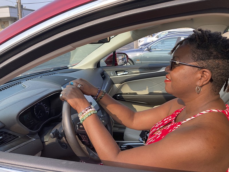 Jessica Pitts sits behind the wheel of a 2019 Lincoln MKC on the lot of Jack Demmer Lincoln in Dearborn, Mich., on Monday, July 19, 2021. Pitts bought the used car at the dealership. A seemingly endless streak of skyrocketing used vehicle prices is finally coming to a close in the U.S., according to the latest data (AP Photo/Mike Householder)