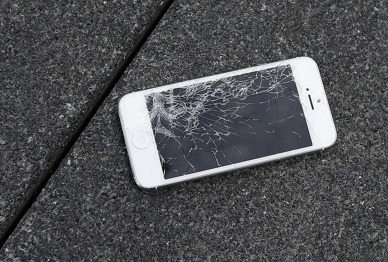 FILE - This Aug. 26, 2015 photo shows an Apple iPhone with a cracked screen after a drop test from the DropBot, a robot used to measure the sustainability of a phone to dropping, at the offices of SquareTrade in San Francisco.   Responding to a new competition directive from the Biden White House, Wednesday, July 21, 2021,  the Federal Trade Commission is moving toward writing new rules aimed at helping small repair businesses and saving consumers money on repair costs. Unavailable parts, instruction manuals, design restrictions and locks on software have made many consumer products harder to fix, regulators say. (AP Photo/Ben Margot, File)