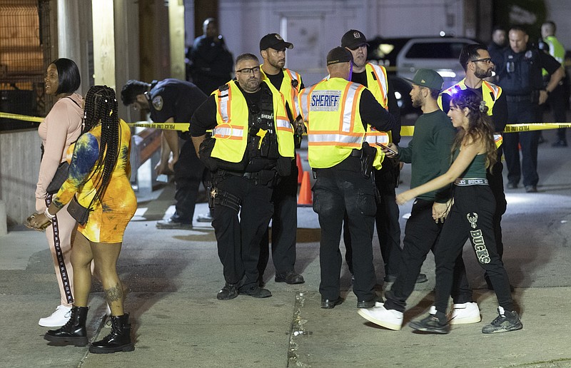 Milwaukee County Sheriff's deputies and Milwaukee Police officers investigate the scene of shooting early Wednesday, July 21, 2021 at Elwood's Liquor & Tap, 1111 N. Water St. in Milwaukee. Police say two shootings, that left three people wounded, occurred in downtown Milwaukee early Wednesday as crowds celebrated the Milwaukee Bucks' first NBA championship in 50 years.  (Mark Hoffman/Milwaukee Journal-Sentinel via AP)