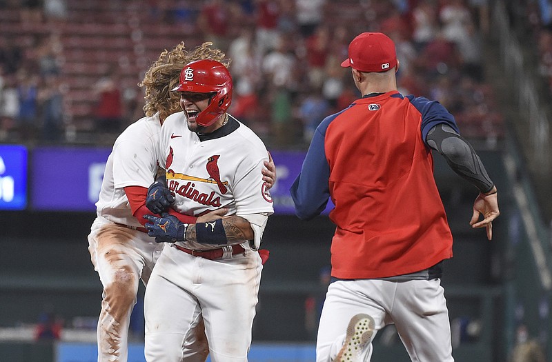Yadier Molina is congratulated by some Cardinal teammates after driving in the game-winning run in the 10th inning of Wednesday night's 3-2 victory against the Cubs at Busch Stadium.