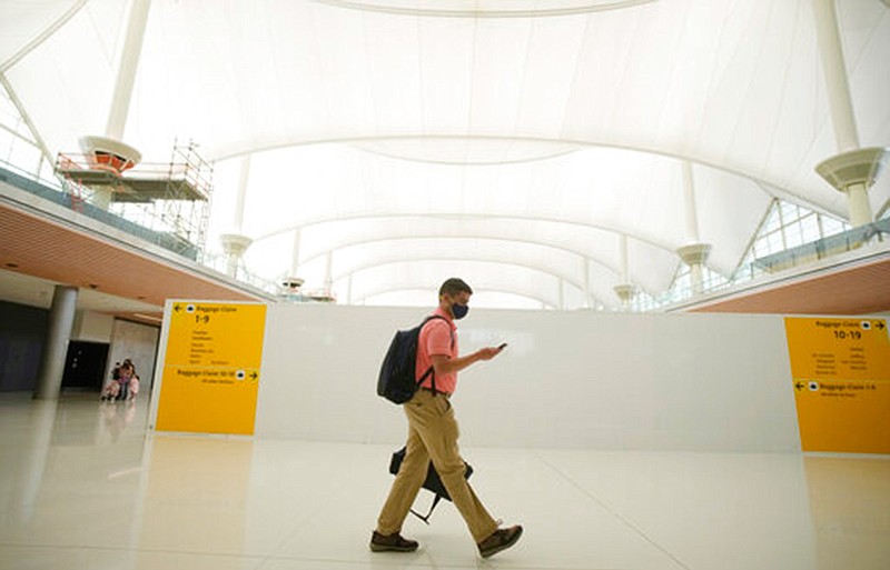 A lone traveler passes the construction zone on the way to the gates at Denver International Airport on July 2, 2021. To fly for the lowest price on your next trip, try searching without a specific destination or date in mind. You can save money and points if you're willing to be flexible with your travel dates and locations. (AP Photo/David Zalubowski, File)
