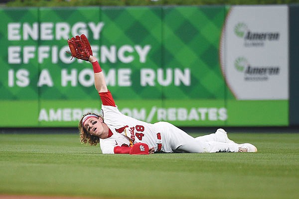 Cardinals center fielder Harrison Bader holds up his glove after catching a fly ball hit by Nico Hoerner of the Cubs during the seventh inning of Thursday night's game at Busch Stadium.