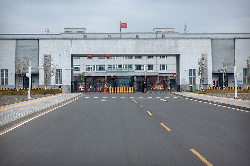 Police officers stand at the outer entrance of the Urumqi No. 3 Detention Center in Dabancheng in western China's Xinjiang Uyghur Autonomous Region on April 23, 2021. Urumqi No. 3, China's largest detention center, is twice the size of Vatican City and has room for at least 10,000 inmates. (AP Photo/Mark Schiefelbein)