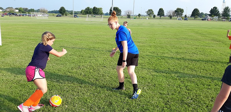 Camille Ragsdale, middle, camp director and coach with Challengers Sports, runs a touring week-long soccer camp, visiting cities and drilling students on the fundamentals of soccer. She leads charges through a session of monkey-in-the middle, one of the drills keeping her students sharp.