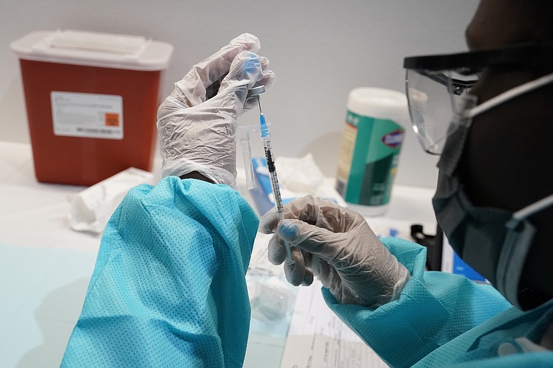 FILE - In this July 22, 2021 file photo, a health care worker fills a syringe with the Pfizer COVID-19 vaccine at the American Museum of Natural History in New York.  Most Americans who haven’t been vaccinated against COVID-19 say they are unlikely to get the shots and doubt they would work against the aggressive delta variant despite evidence they do, according to a new poll that underscores the challenges facing public health officials amid soaring infections in some states.(AP Photo/Mary Altaffer)