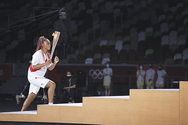 Naomi Osaka carries the Olympic Torch during Friday's opening ceremony in the Olympic Stadium at the 2020 Summer Olympics in Tokyo, Japan.