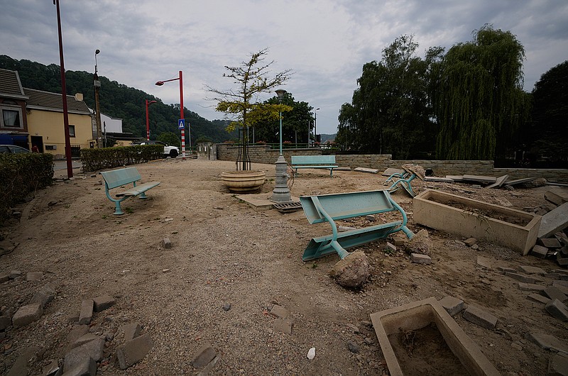 Chairs are upended and debris is scattered in a square after flooding in Vaux-sous-Chevremont, Belgium, Saturday, July 24, 2021. Residents were still cleaning up after heavy rainfall hit the country causing flooding in several regions. (AP Photo/Virginia Mayo)