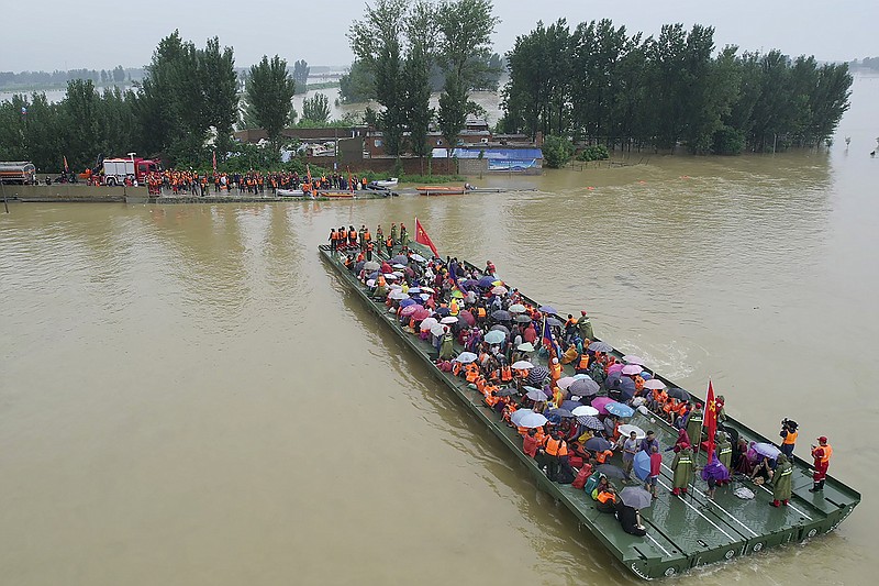 Rescuers use a motorized raft bridge to evacuate residents from a flooded rural area in Xinxiang in central China's Henan Province, Friday, July 23, 2021. The death toll from catastrophic flooding in the central Chinese city of Zhengzhou has continued to rise, state media reported Friday. The official China Daily newspaper and other media said the number included just Zhengzhou, the capital of Henan province. Other areas of the province have also faced heavy downpours, and rivers and reservoirs burst their banks. (Chinatopix via AP)