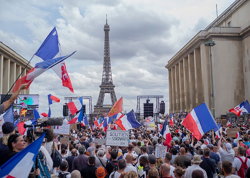 Thousands of protesters gather at Place Trocadero near the Eiffel Tower attend a demonstration in Paris, France, Saturday July 24, 2021, against the COVID-19 pass which grants vaccinated individuals greater ease of access to venues. (AP Photo/Rafael Yaghobzadeh)