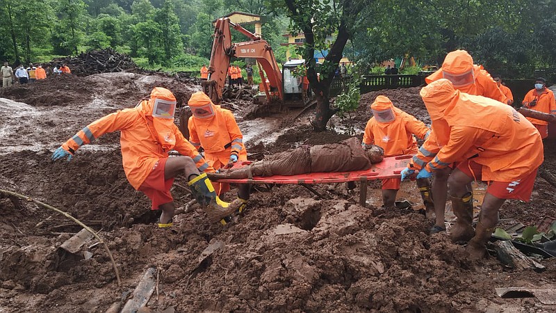 This photograph provided by India's National Disaster Response Force (NDRF) shows NDRF personnel recovering the body of a landslide victim at Ratnagiri in the western Indian state of Maharashtra, Sunday, July 25, 2021. Officials say landslides and flooding triggered by heavy monsoon rain have killed more than 100 people in western India. (National Disaster Response Force via AP)